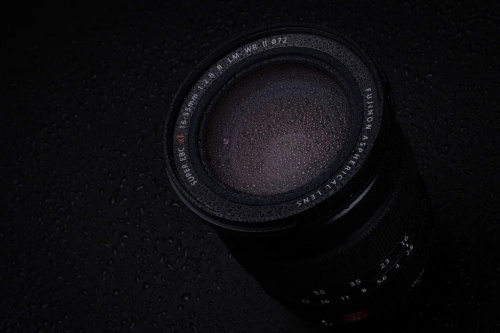 alt="Camera lens with water droplets"