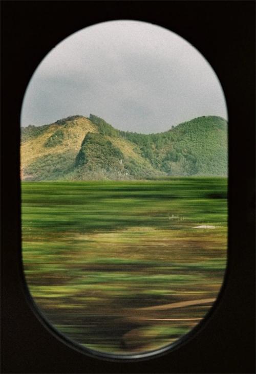 alt="Landscape with motion blur seen through a train window"