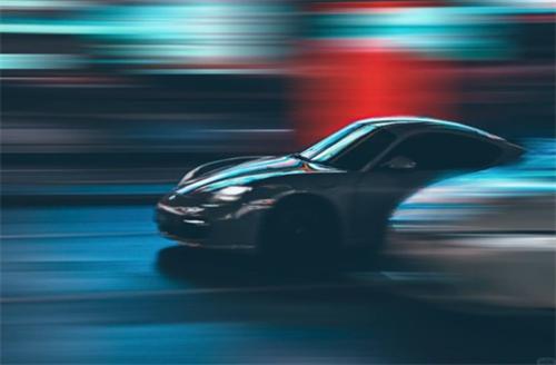 alt="Panning shot of a fast car at night"