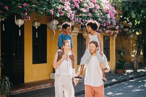 alt="Happy family walking in a historic street"
