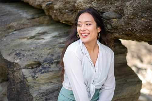 alt="Outdoor lifestyle photo of a woman laughing in nature"