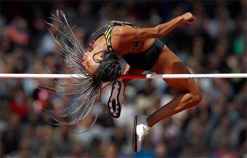 alt="Female athlete high jump action shot"
